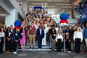 Group of WWT interns on stairs in lobby of global headquarters, celebrating the start of an internship program.