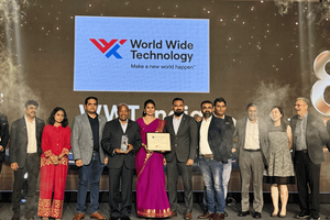 A group of people smile and gather together on a stage with an award. The World Wide Technology logo and the number 8 is visible in the background.