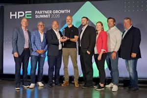 Group of eight individuals on stage at the HPE Partner Growth Summit 2026 posing together, with two people at center holding an award trophy in front of a branded event backdrop.