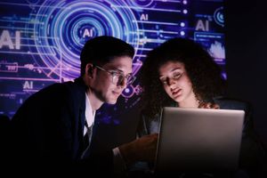 Two people collaborate on a laptop in front of a glowing digital interface filled with AI graphics and data visualizations.