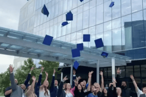 WWT Associates throwing their graduation caps in the air outside WWT's global headquarters in St. Louis