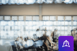 Artistically blurred photo of a conference room with people sitting in chairs, with the WWT Research logo superimposed over the image.