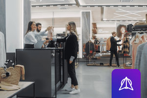 Clothing Store Checkout Cashier Counter Where a Woman is Buying a Blouse from a Sales assistant, Paying with Contactless Credit Card