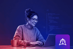 A woman with glasses smiles while typing on a laptop at a desk, lit in blue and red tones, with a coffee mug and notebook beside her. Code and a stylized code icon are overlaid in the background, and a purple app icon appears in the bottom right corner.