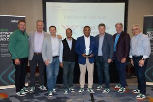 Award recipients and partner representatives pose together on stage in front of a screen recognizing World Wide Technology as Partner of the Year at an Infoblox Partner Advisory Board event, with one attendee holding the award.
