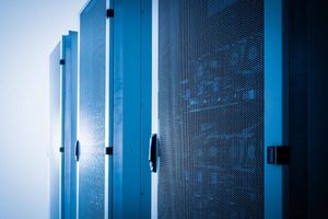 Rows of blue-lit server racks in a data center, highlighting enterprise IT infrastructure and computing capacity.