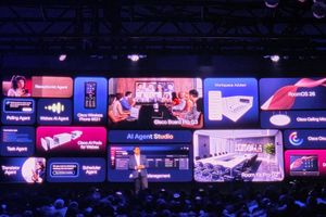 A presenter at WebexOne stands in front of a screen of new Cisco AI agents, room devices and software.