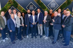 People celebrating an award win at the Cisco Partner Summit 2026, showcasing awards and smiles.